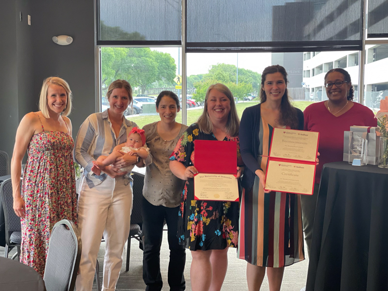 two women holding diplomas