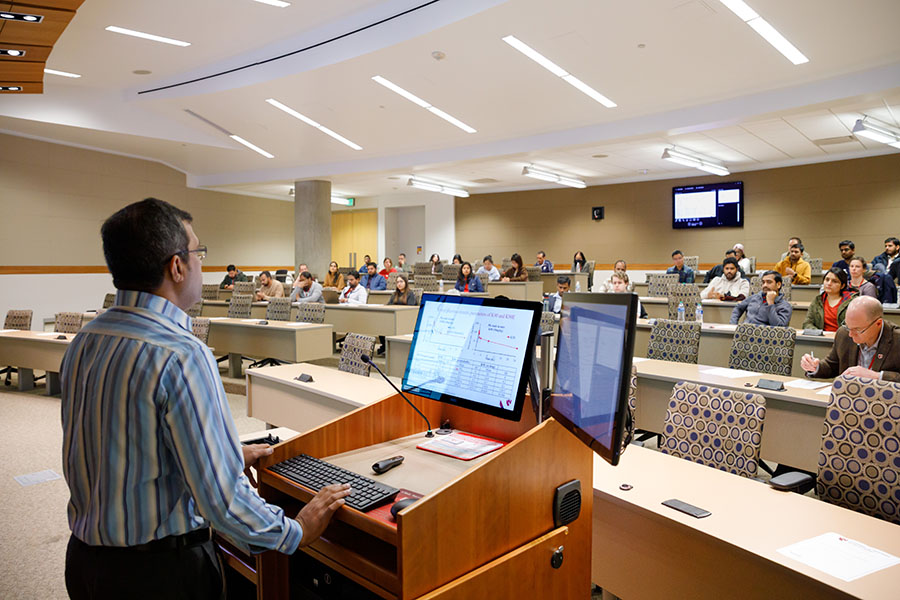 Researcher giving podium presentation to an audience