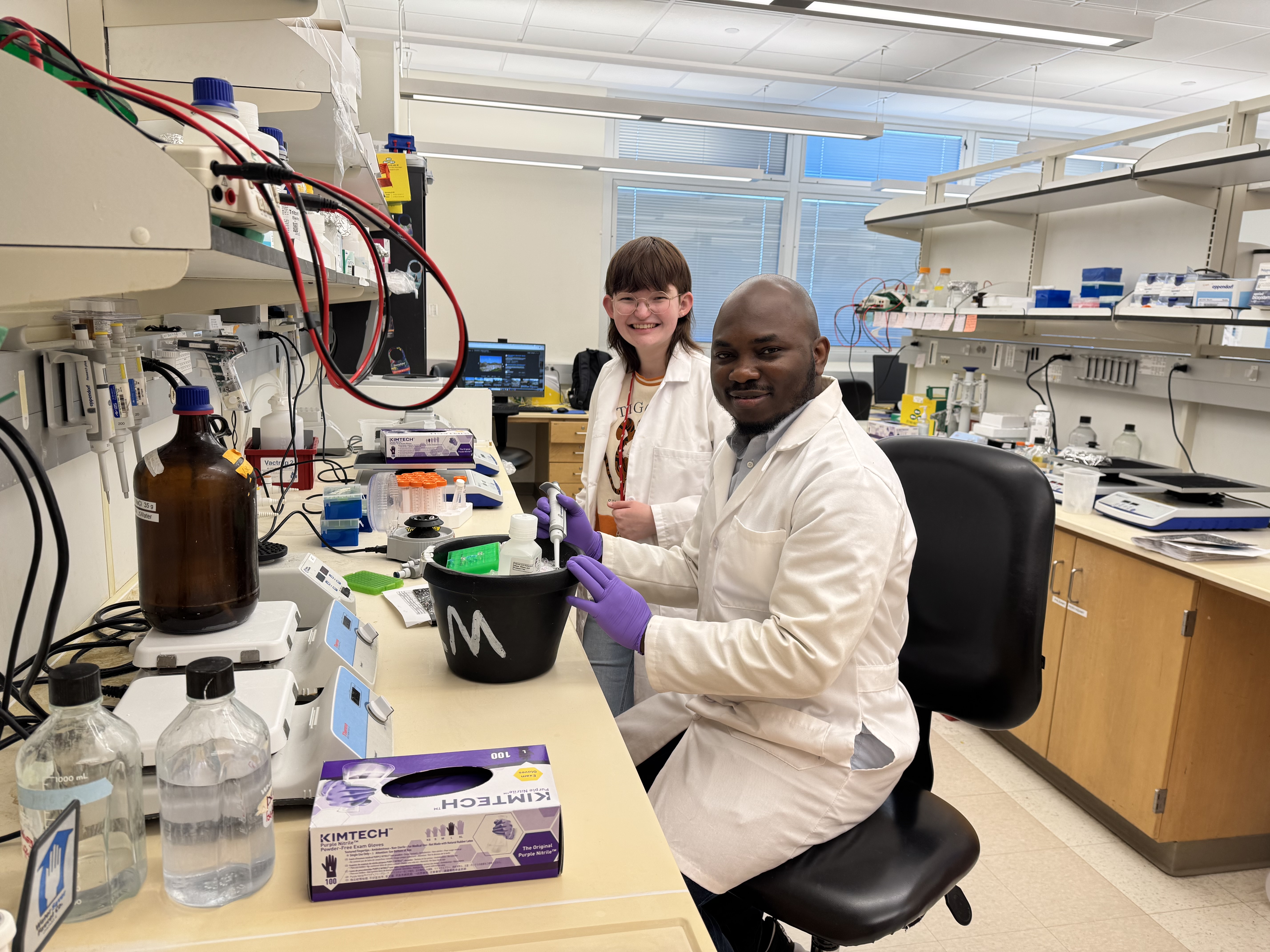 Postdoc teaches lab techniques to MCC student