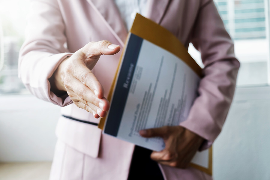 Job candidate holding out hand to shake mentors hand