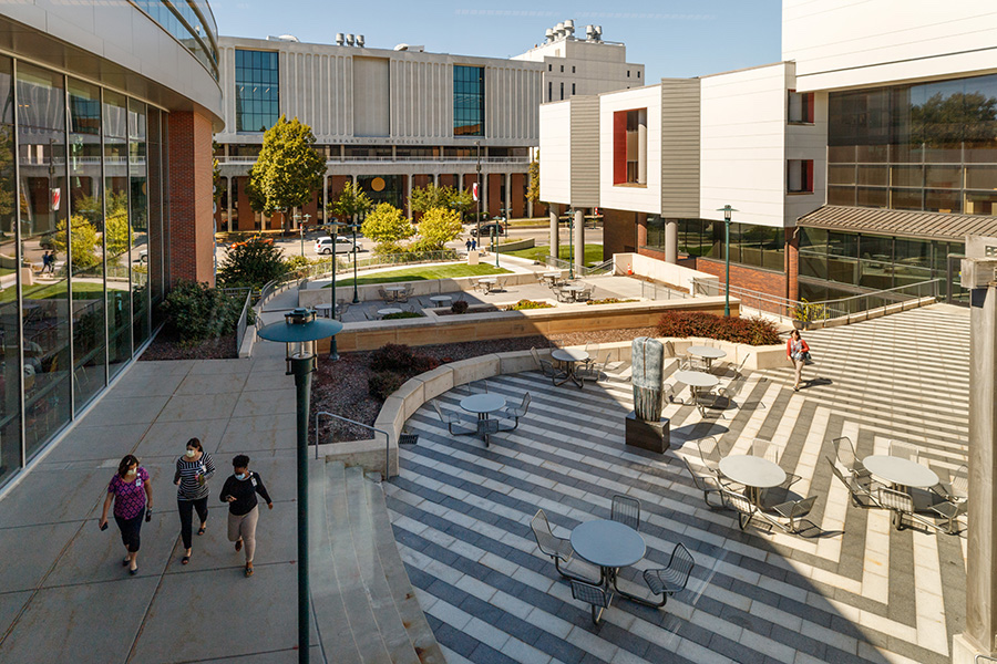 Three students walking on campus. 