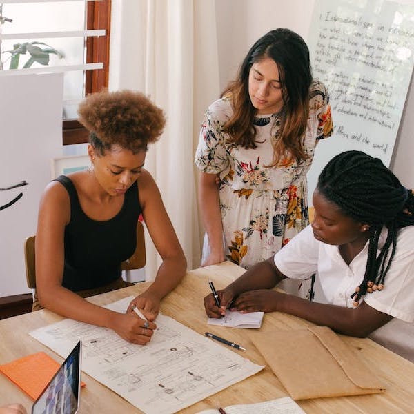 A group of students working at a desk.