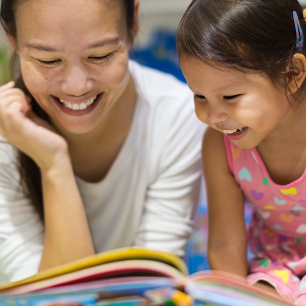 A mother and her child reading a book.