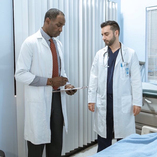 Two doctors standing in a hospital room.