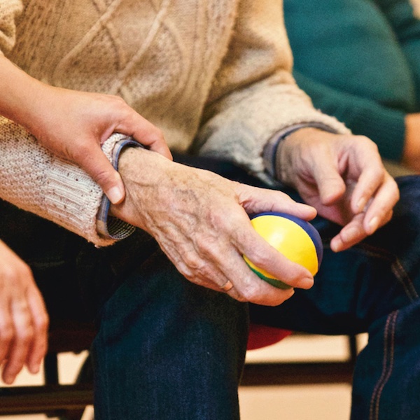 An elderly person holding a ball.