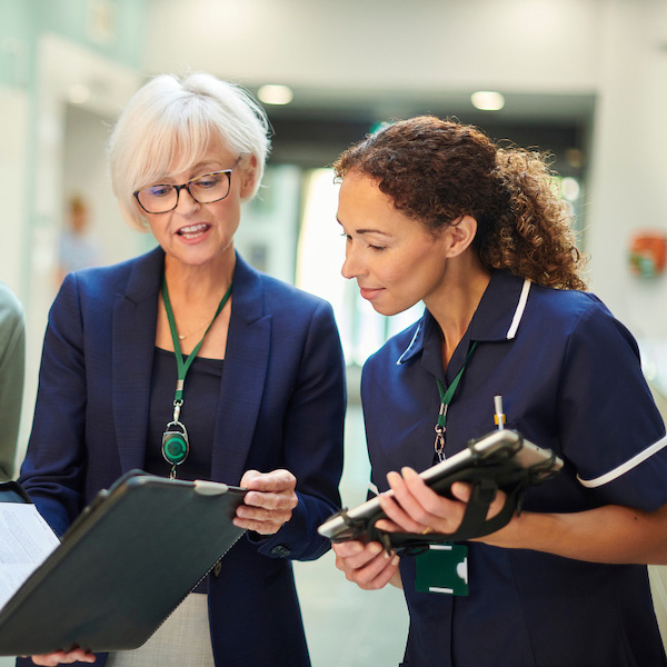 Two health practitioners looking over a clipboard.