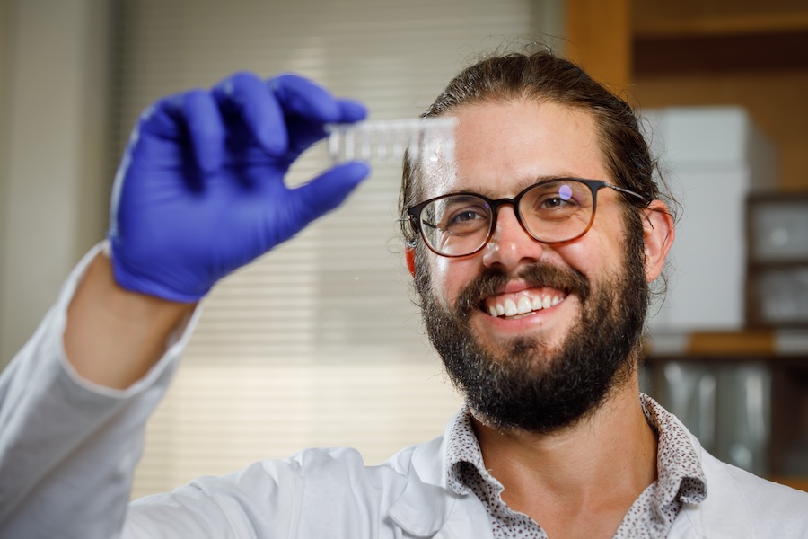 A person in a lab holding up a pipette tray.