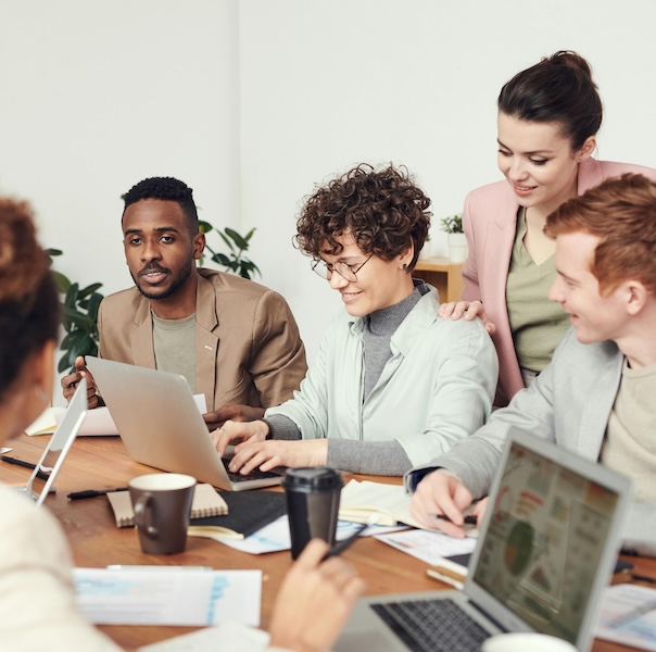 A group of professionals in a meeting around a desk.