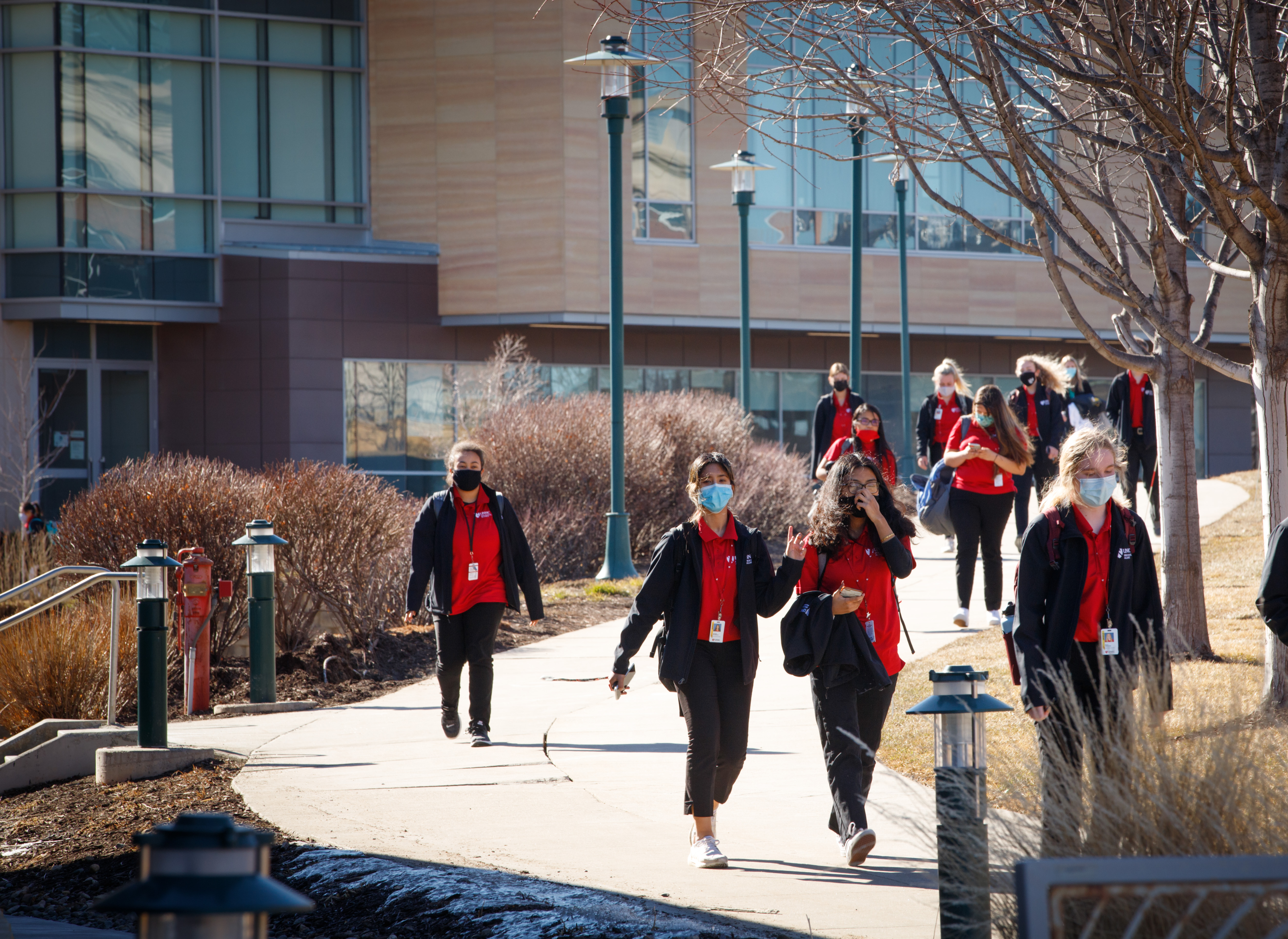 Students in red shirts walking across campus