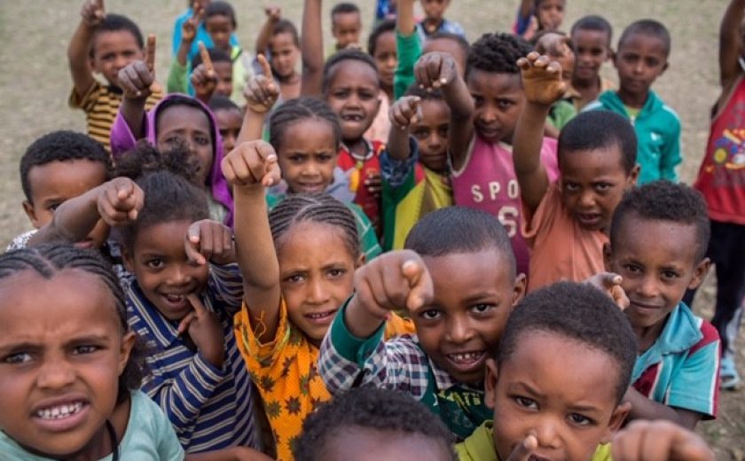 Image of children from Ethiopia looking and pointing at the camera.