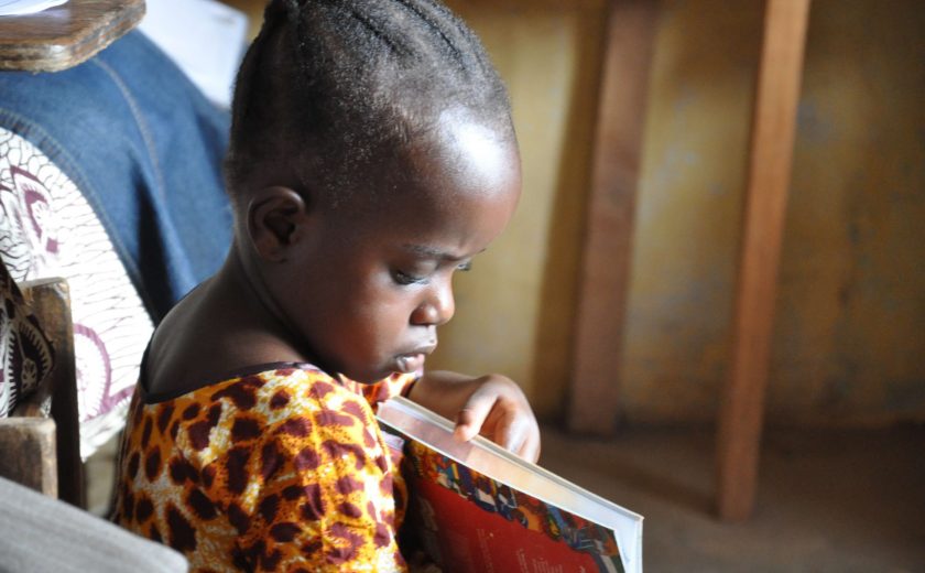 Image of a young girl from Liberia looking through a book