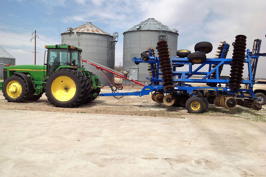 Image of tractor and grain silos on farmland
