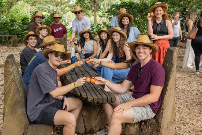 students outdoors listening to a professor