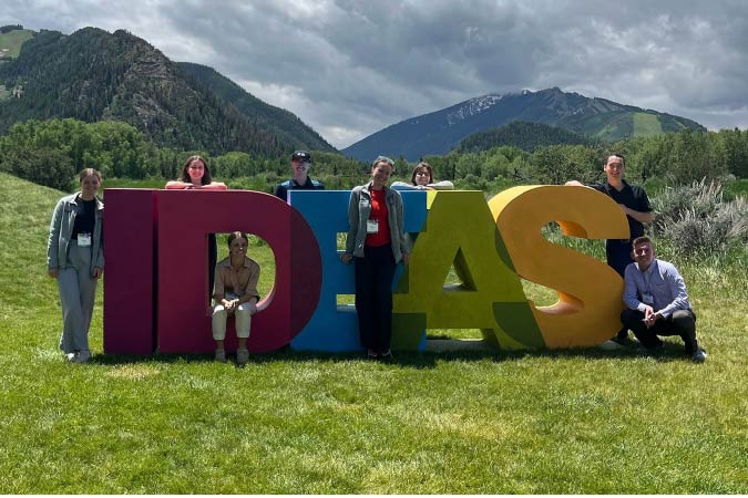 students standing by an IDEAS statue