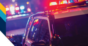 Image of a police car with its lights on at night.