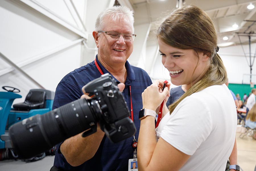 A photographer shows a photo to a student