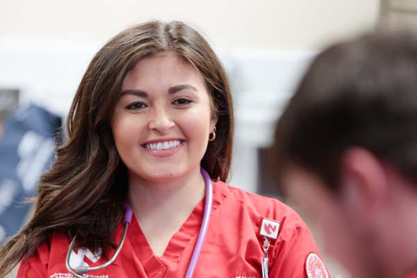 a female nursing student in red scrubs