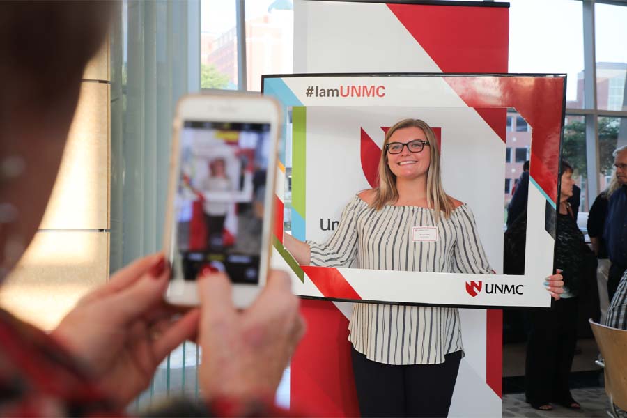 A female student with a nametag poses for a picture