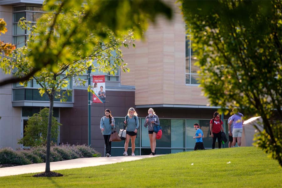 A group of three students walks outside on the UNMC campus