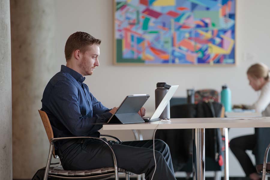 A male student looks at a laptop