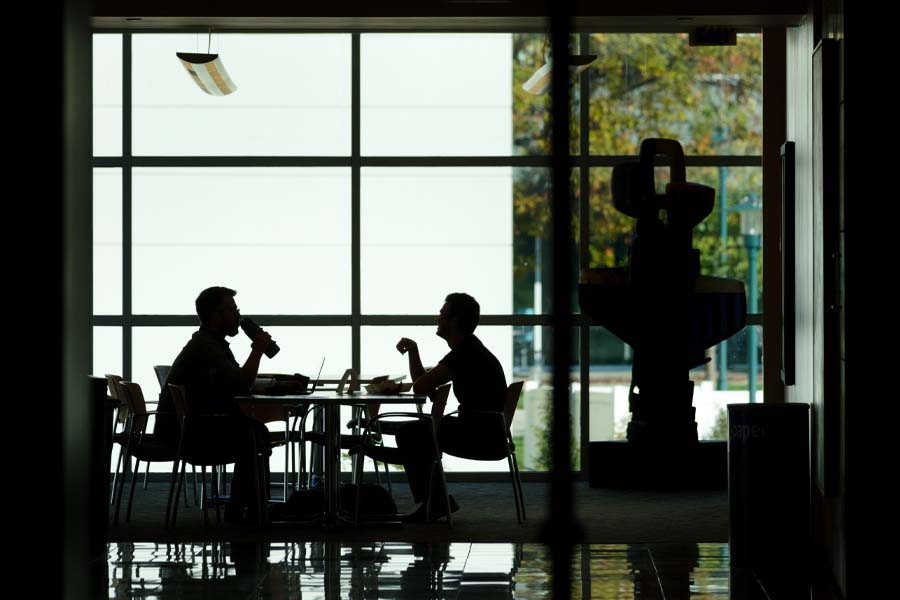 Silhouettes of two students sitting in front of a window
