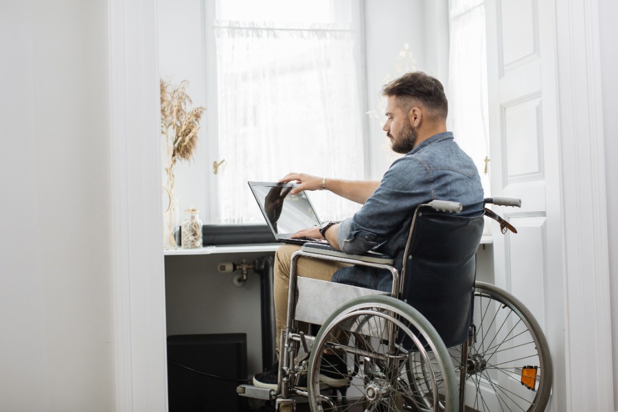 a male student in a wheelchair studies at a desk
