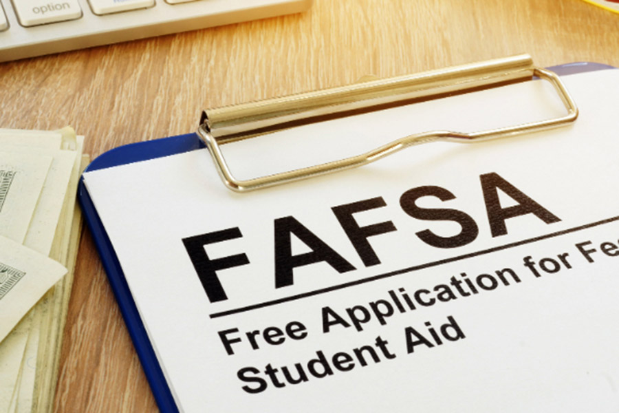 clipboard and FAFSA application, money bills, laptop computer