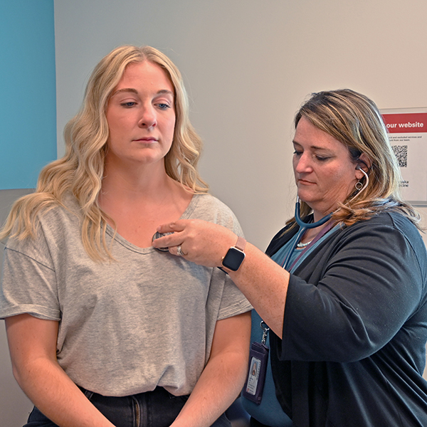 a nurse check's a female student's vitals at the student health clinic