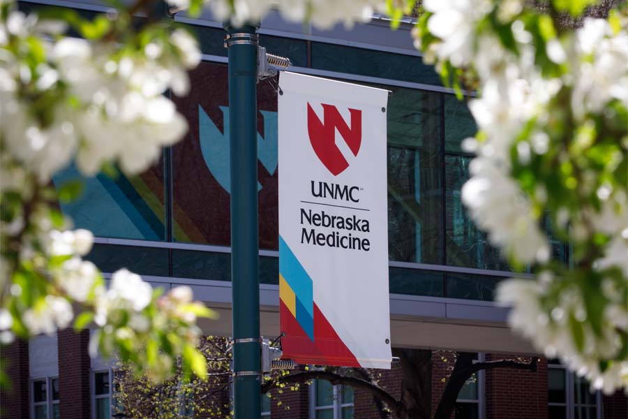 A unmc/Nebraska Medicine banner surrounded by spring blossoms