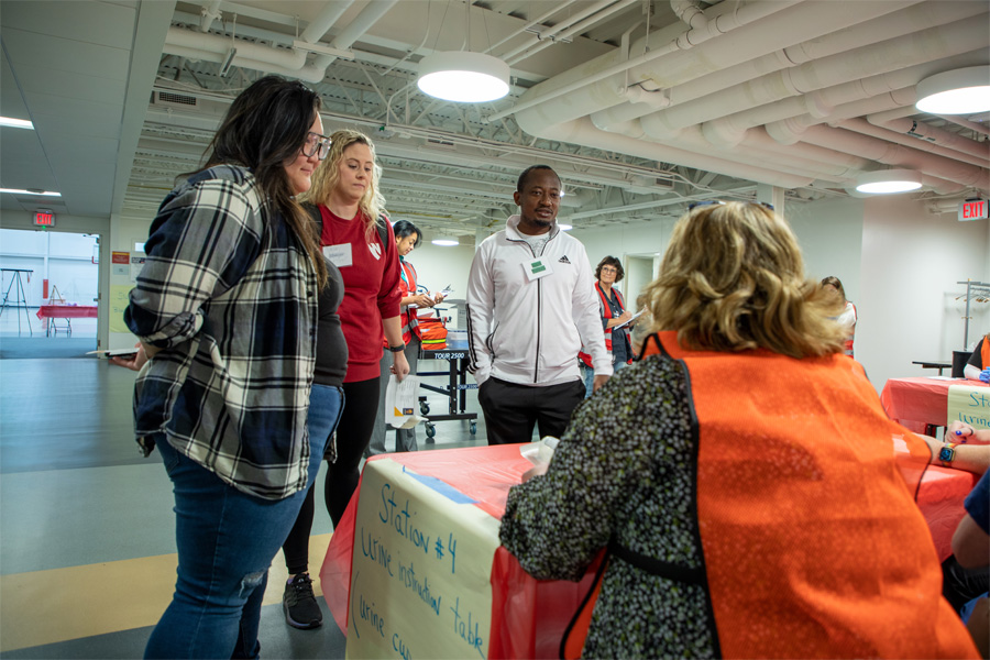 Three students stand at an informational booth