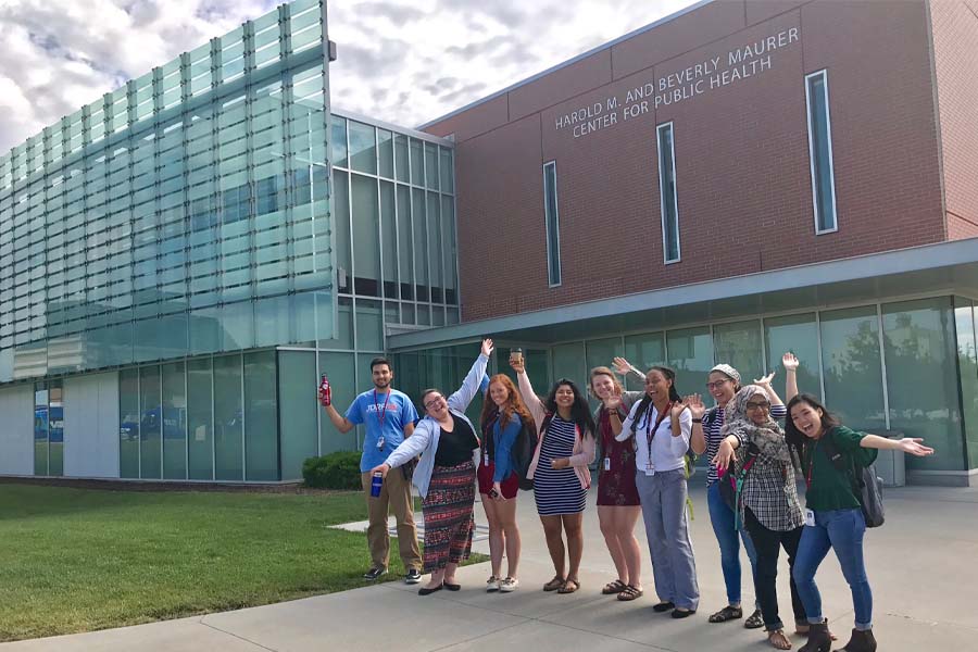 Nine SHPEP students pose in front of the College of Public Health building