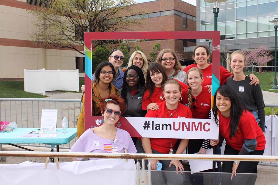 A group of students poses behind a booth