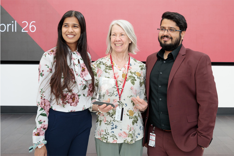 Three people pose for a photo after winning an award