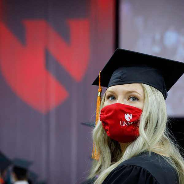 A female students wears a cap and gown at UNMC's graduation