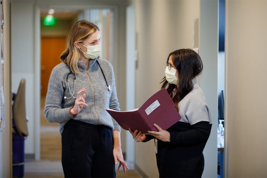 Two UNMC staff converse in a hallway