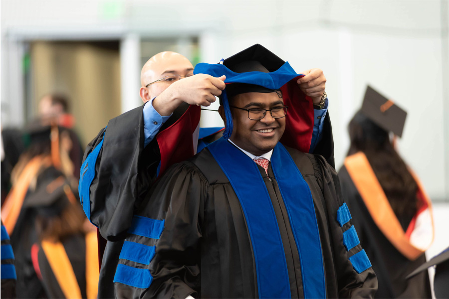 A student receives his stole during a graduation ceremony