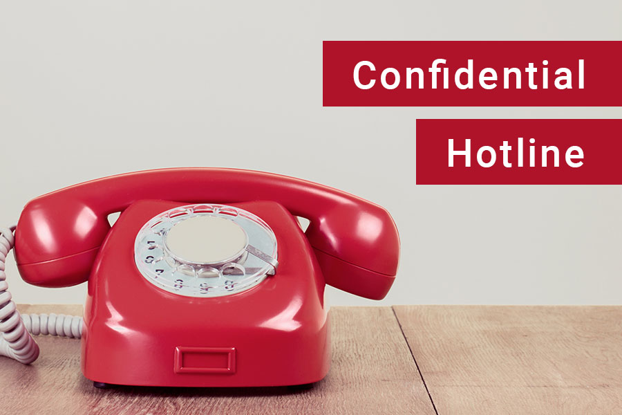 red telephone labeled as a confidential hotline