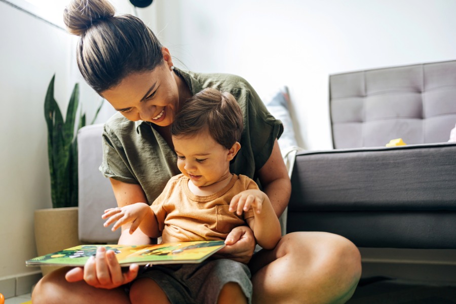 a mom holds her preschool son on her lap