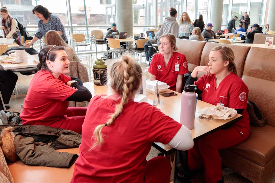 Four nursing students sit in a booth