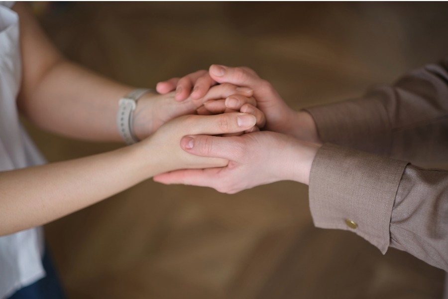 two sets of hands, one cradling the other in support