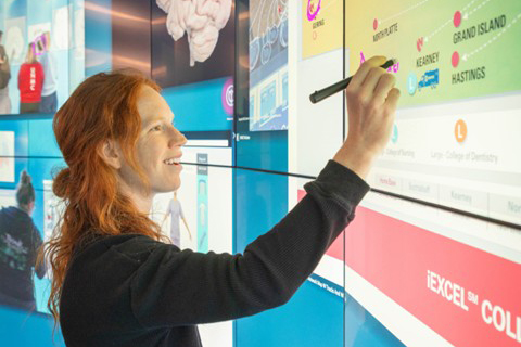 student writing on an interactive learning board