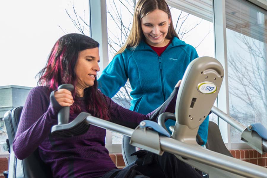 Two women work on a fitness machine