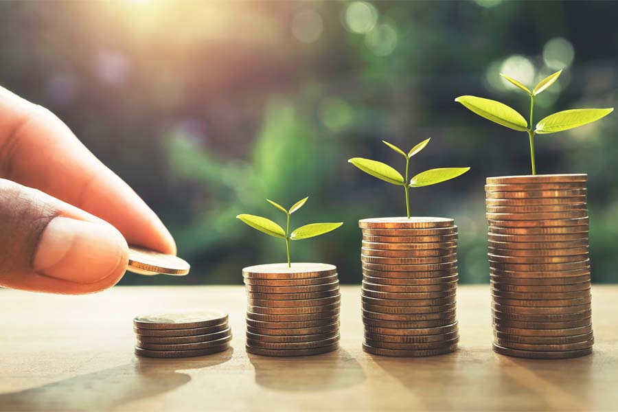 A stock image of a hand reaching toward piles of coins